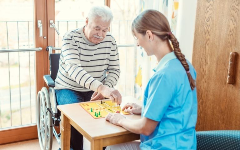 Residential worker and resident playing a board game